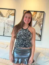 Top halter negro con lentejuelas plateadas y blancas, breteles finos que se atan al cuello y espalda descubierta.