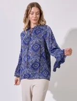 Blusa de satén estampada en tonos azules, con escote en V y lazo, y mangas largas con volados.