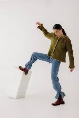 Pantalón de jean azul oscuro de corte recto, con cintura alta con cinturón del mismo material y detalle de flecos en la cintura y en los tobillos.