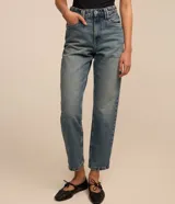Pantalón mom confeccionado en jeans celeste, con cintura con trabillas dobles, cierre por botón y cremallera, bolsillos delanteros y traseros, y lateral desplazada.