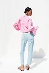 Pantalón de jean celeste claro, de corte mom fit, tiro alto y largo tobillero.