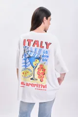 Remera blanca de corte amplio con mangas cortas y estampado en la espalda con la palabra "Italy", un aperitivo, una copa y la frase "La dolce vita".