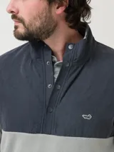 Micropolar gris con cuello alto y medio cierre con snaps. Tiene aplicación de tela en el canesú, dos bolsillos invisibles y parche con logo de pato.