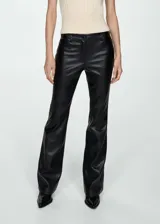 Pantalón negro de efecto piel, tiro medio, corte flare y cinco bolsillos.
