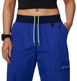 Pantalón negro de mujer, de corte recto y tiro alto, con cintura elástica ajustable con cordón, bolsillos laterales y bolsillo adicional en la pierna. Cuenta con puños ajustables con cordón y forro de malla para mayor transpirabilidad.