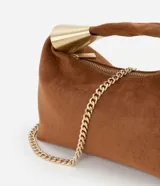Bolso bandolera pequeño de gamuza color marrón con asa corta rígida y correa de cadena dorada.