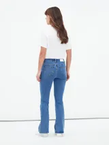 Jean de mezclilla azul de tiro alto, corte ajustado en muslos y pierna acampanada (estilo Oxford o flare).