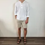 Camisa blanca de muselina con cuello mao y manga larga con puños abotonados.