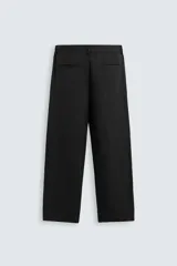 Pantalón de vestir color blanco hueso, de corte recto y tiro medio, con cintura elástica y cierre frontal de botón y cremallera. Presenta bolsillos frontales y bolsillos traseros de vivo.