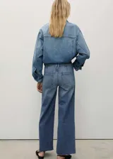 Pantalón de jean azul de corte culotte, tiro alto, con cierre de cremallera y botón, bolsillos traseros, bajo deshilachado y tejido elástico.