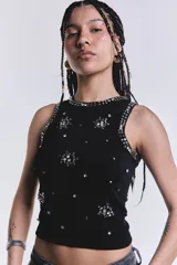 Musculosa negra de punto acanalado con cuello redondo y apliques de strass plateados en forma de flores y tachas alrededor del cuello y las sisas.