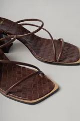 Sandalias de tacón color marrón chocolate con capellada trenzada, punta cuadrada y dos tiras finas sobre el empeine. Tacón cuadrado.