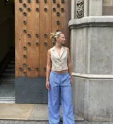 Pantalón palazzo celeste a rayas verticales blancas, de tiro alto y corte holgado.