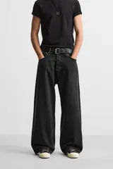 Pantalón de jean negro de corte amplio, con cinco bolsillos, efecto lavado y cierre frontal con cremallera y botón.