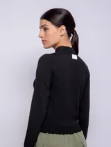 Polera de punto gris con cuello alto y manga larga, diseñada como una prenda básica de invierno.