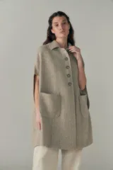 Capa larga color marrón claro con textura tipo tweed, con botones en la parte delantera y bolsillos laterales.