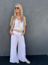 Pantalón palazzo de lino blanco, con cintura elástica, bolsillos laterales y presillas para cinturón.