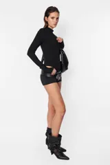 Body blanco de algodón con lycra, de manga larga con detalle de mitón en los puños y cuello media polera.