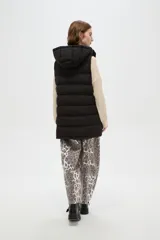 Chaleco puffer negro con capucha ajustable, cierre frontal con botones a presión y bolsillos laterales con cierre.
