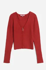 Sweater rojo de tejido de punto acanalado, con escote en V y cierre frontal con cremallera circular.