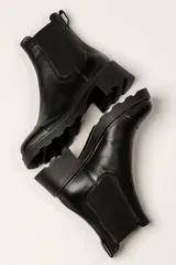 Bota Chelsea de cuero color marrón con elástico lateral negro, suela track y taco cuadrado.