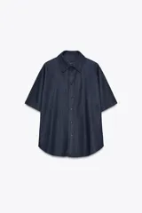 Camisa de denim azul oscuro, de corte recto, con cuello clásico, manga corta y cierre frontal con botones.