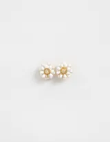 Par de aros pasantes con forma de flor esmaltada blanca con centro dorado y cierre de tope a presión.