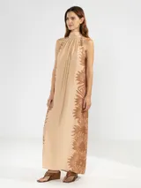 Vestido largo color naranja con estampado de flores rosas, corte recto, cuello halter y espalda descubierta.