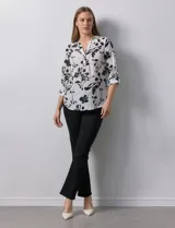 Blusa de gasa estampada con flores, marca Zac & Rachel. Tiene cuello a la base, escote en V y abertura con botones. Las mangas largas son de largo regulable.