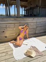 Conjunto de bikini color lila, compuesto por un corpiño triangular con tirantes finos y una bombacha con tiras finas ajustables en los laterales.