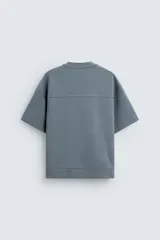 Sudadera azul de corte holgado, cuello redondo y manga corta.