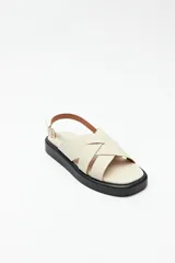 Sandalias negras de símil cuero con agarre ajustable en el talón y capellada entrelazada. Plataforma de 3 cm de alto.