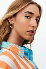 Aros tipo argolla color dorado con textura ondulada.