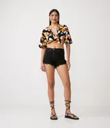 Short de jean negro, tiro alto, con terminación desflecada.