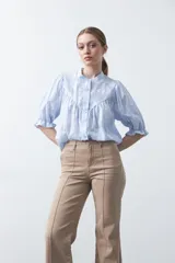 Pantalón negro de tiro alto, corte recto y silueta clásica. Presenta costuras verticales marcadas en la parte delantera de las piernas.