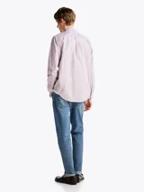 Camisa Tommy Hilfiger de corte regular, confeccionada en popelina de algodón a rayas verticales rojas, azules y blancas. Cuenta con cuello abotonado, mangas largas con puños abotonados, logo bordado en el pecho y tecnología Flex para mayor comodidad.