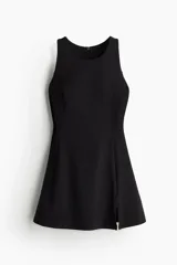 Vestido corto de tenis negro, de corte ajustado, sin mangas y con cierre en la espalda. Incluye short interior con top integrado con relleno extraíble y bolsillos laterales.