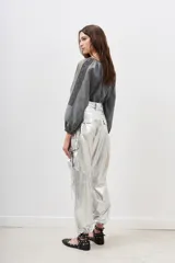 Pantalón plateado metalizado de corte holgado con bolsillos laterales y lazo en la cintura.