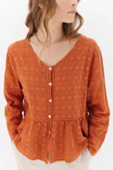 Camisa celeste de algodón con textura arrugada y bordados a tono, escote amplio, mangas largas y botones frontales.