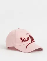 Gorra de béisbol color rosa claro con bordado en relieve de la inscripción "New York" en color borgoña.