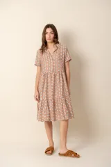 Vestido corto con estampado geométrico en tonos marrón, beige y celeste, con cuello camisero, mangas cortas y corte escalonado.