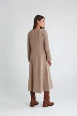 Vestido midi de punto color visón con cuello redondo y mangas largas acampanadas.