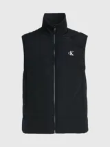Chaleco negro acolchado de nailon reciclado con cuello alto, cierre de cremallera, bolsillos con cremallera en la cintura y logo de Calvin Klein en el pecho y la nuca.