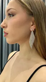 Aros colgantes largos con forma de rombo, cubiertos de strass plateado.
