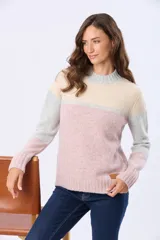 Buzo tejido con diseño de bloques de color en rosa, gris claro y beige. Posee un cuello alto y corte holgado.