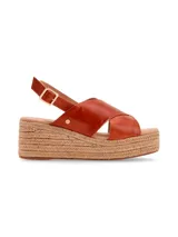 Sandalias de cuero color coñac, con tiras cruzadas en el empeine, pulsera al tobillo con hebilla y plataforma de yute.