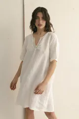 Vestido corto color arena, de lino, con escote en V y mangas cortas.