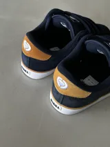 Championes de skate Circa AL 50, color azul marino con detalles en marrón y blanco. Confeccionados en gamuza con puntera de triple costura, lengüeta acolchada con logo y ojales metálicos. Suela vulcanizada.