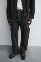 Pantalón relaxed fit confeccionado en denim de algodón color negro. Cuenta con bolsillos frontales, traseros de plastrón y bolsillos multifunción en las perneras. Tiene efecto lavado y cierre frontal con cremallera y botón.