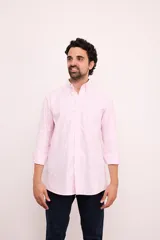 Camisa celeste con rayas verticales blancas, de corte clásico, con cuello abotonado, manga larga y bolsillo en el pecho.